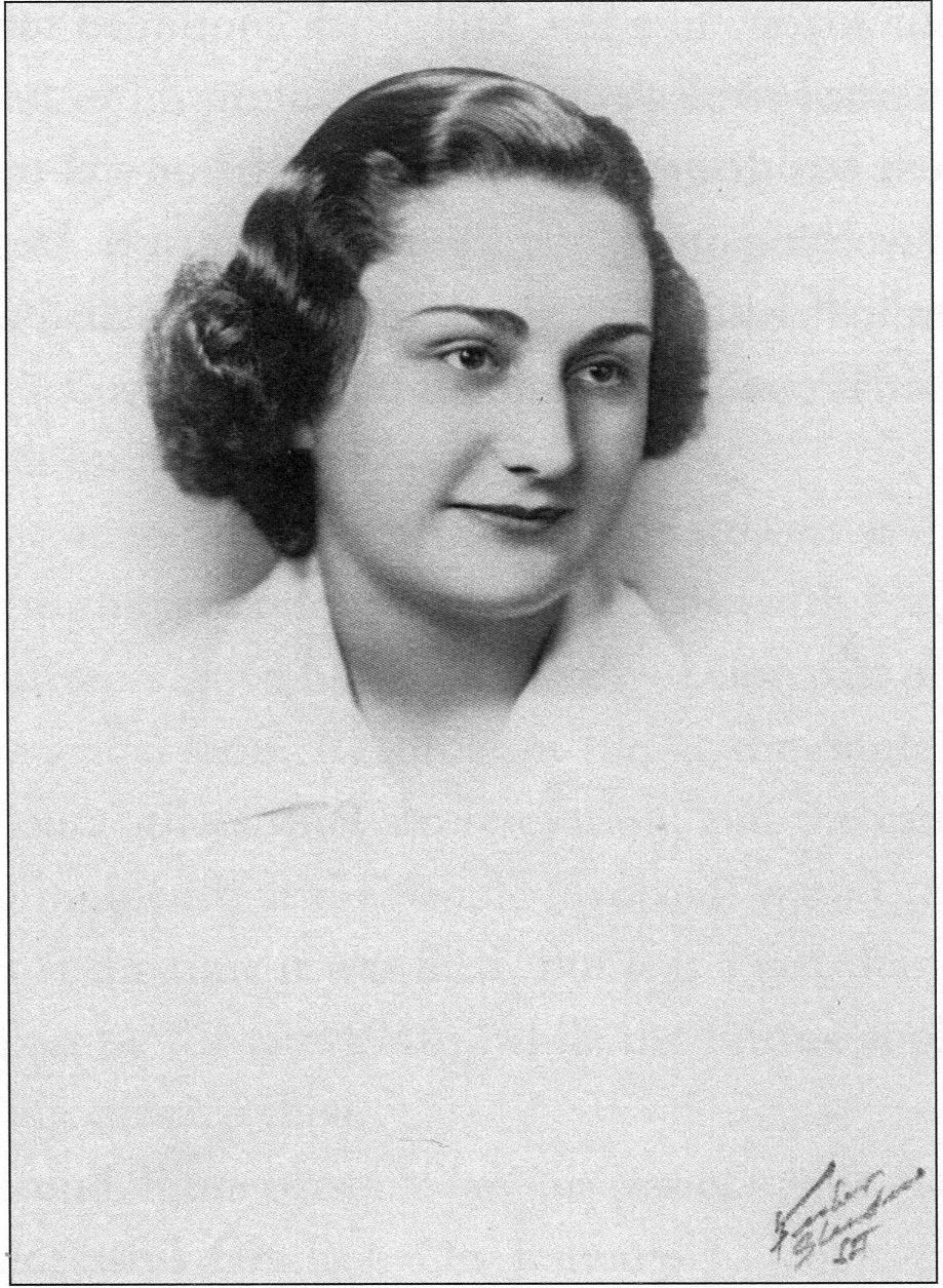 Class picture of Mary looking to her left, she has wavy hair to below her chin and small smile.